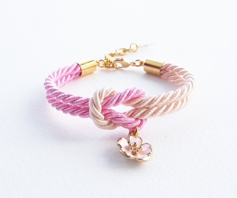 Light pink and ivory cream knot rope bracelet with pink sakura charm - สร้อยข้อมือ - วัสดุอื่นๆ สึชมพู