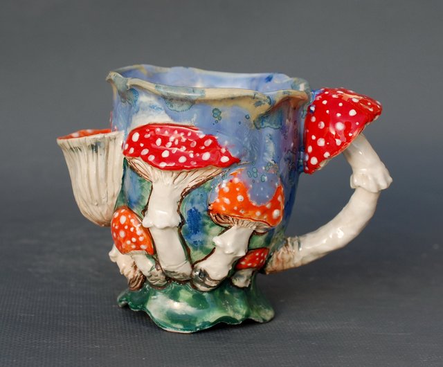 カップの中にポケットの絵が付いているきのこマグティーカップカラフル