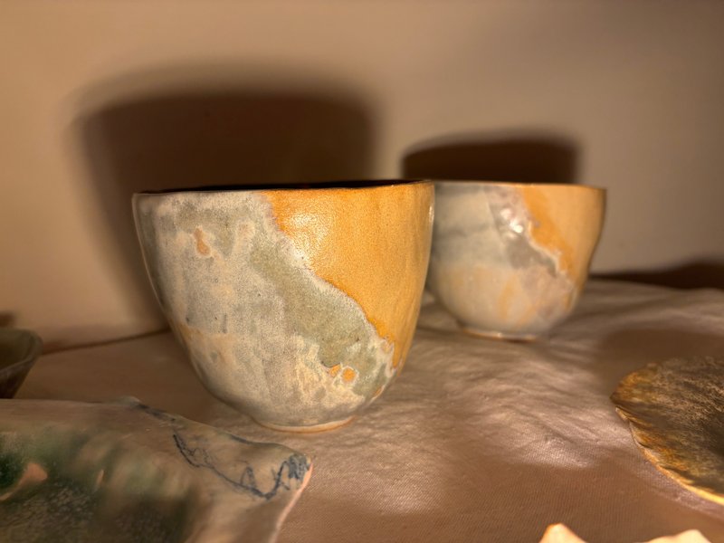 Two people are on the beach in the west - one big and one small, making pottery bowls against each other - Bowls - Pottery 