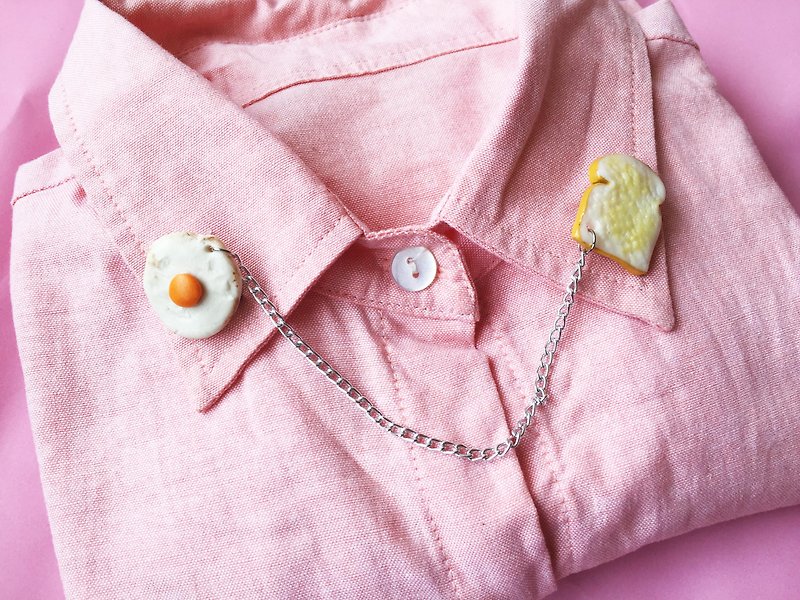 Brooch on the collar, bread + fried egg