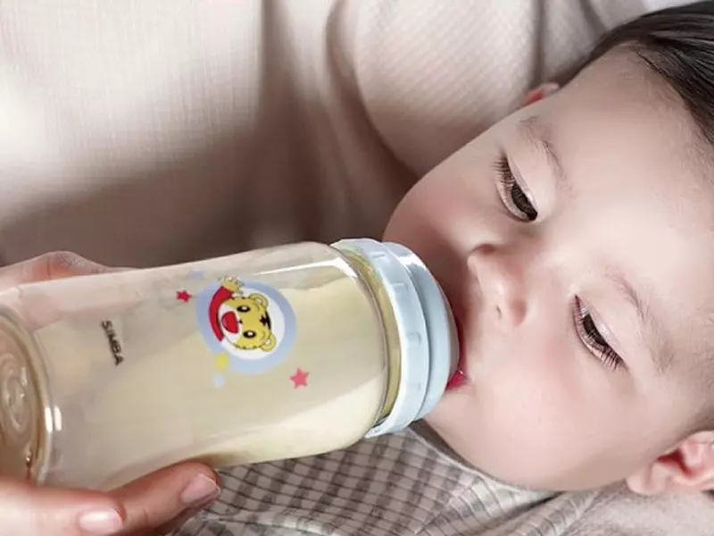 媽媽餵躺著的男嬰喝奶