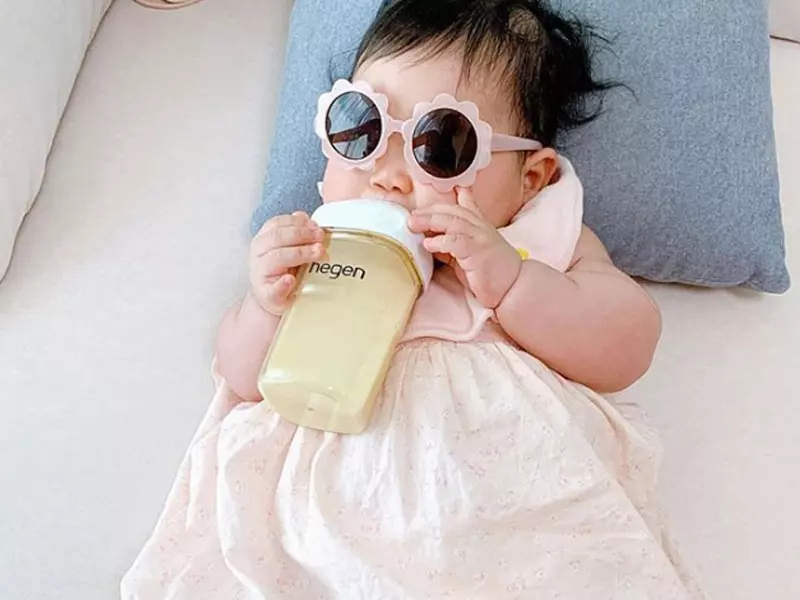 戴著花花眼鏡的女嬰拿著奶瓶喝奶
