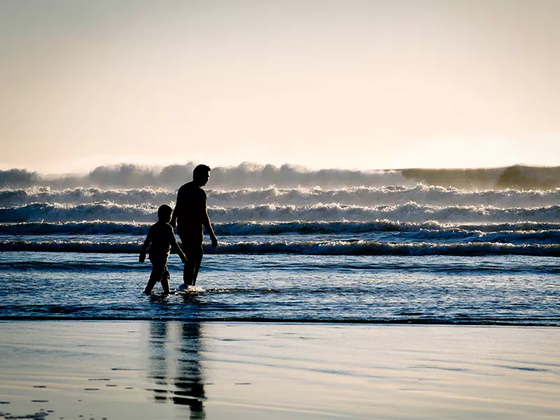 父親與兒子在海邊踏浪